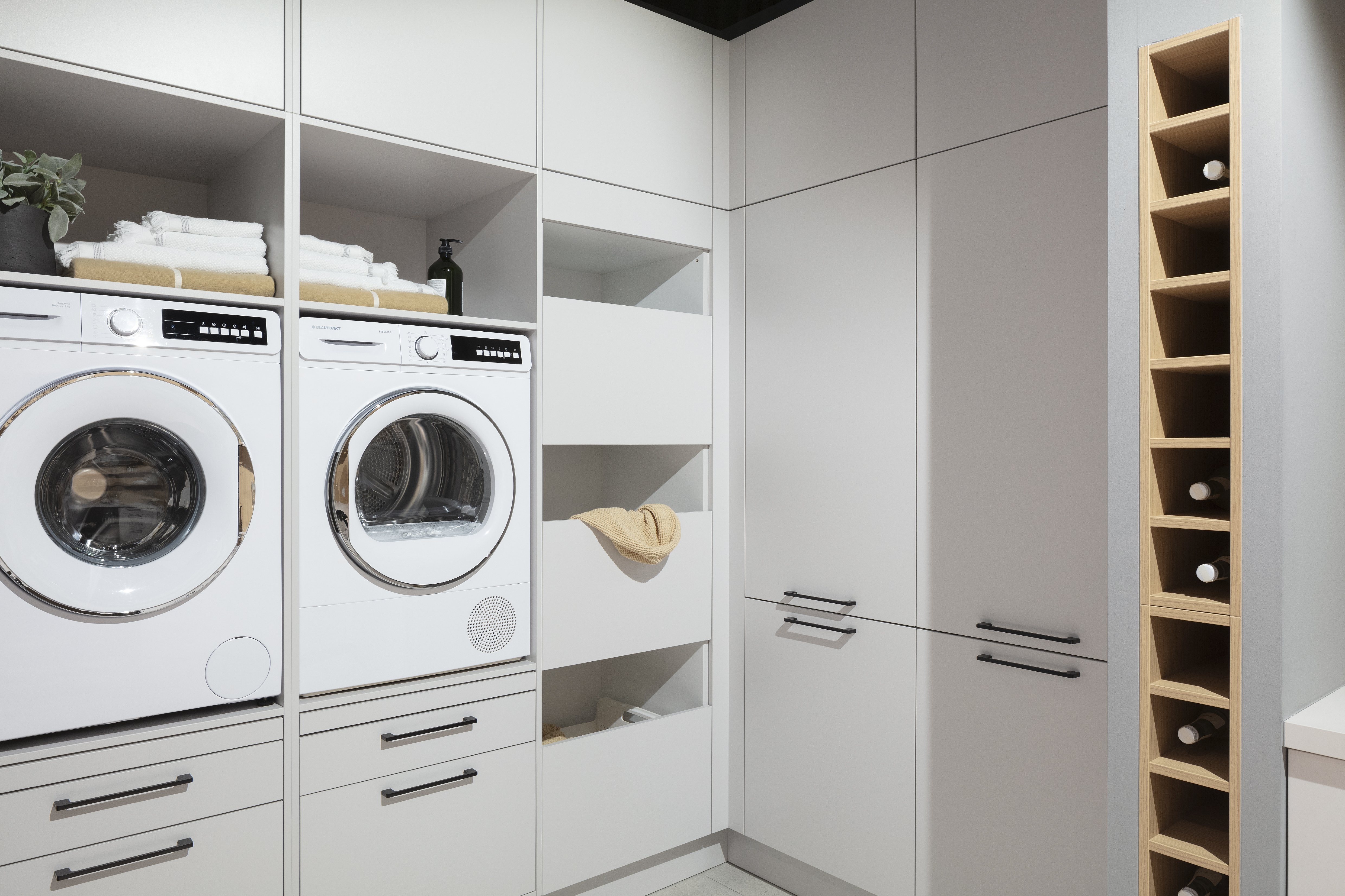 Häcker Hauswirtschaftsraum mit Waschmaschine und Trockner von Blaupunkt. 