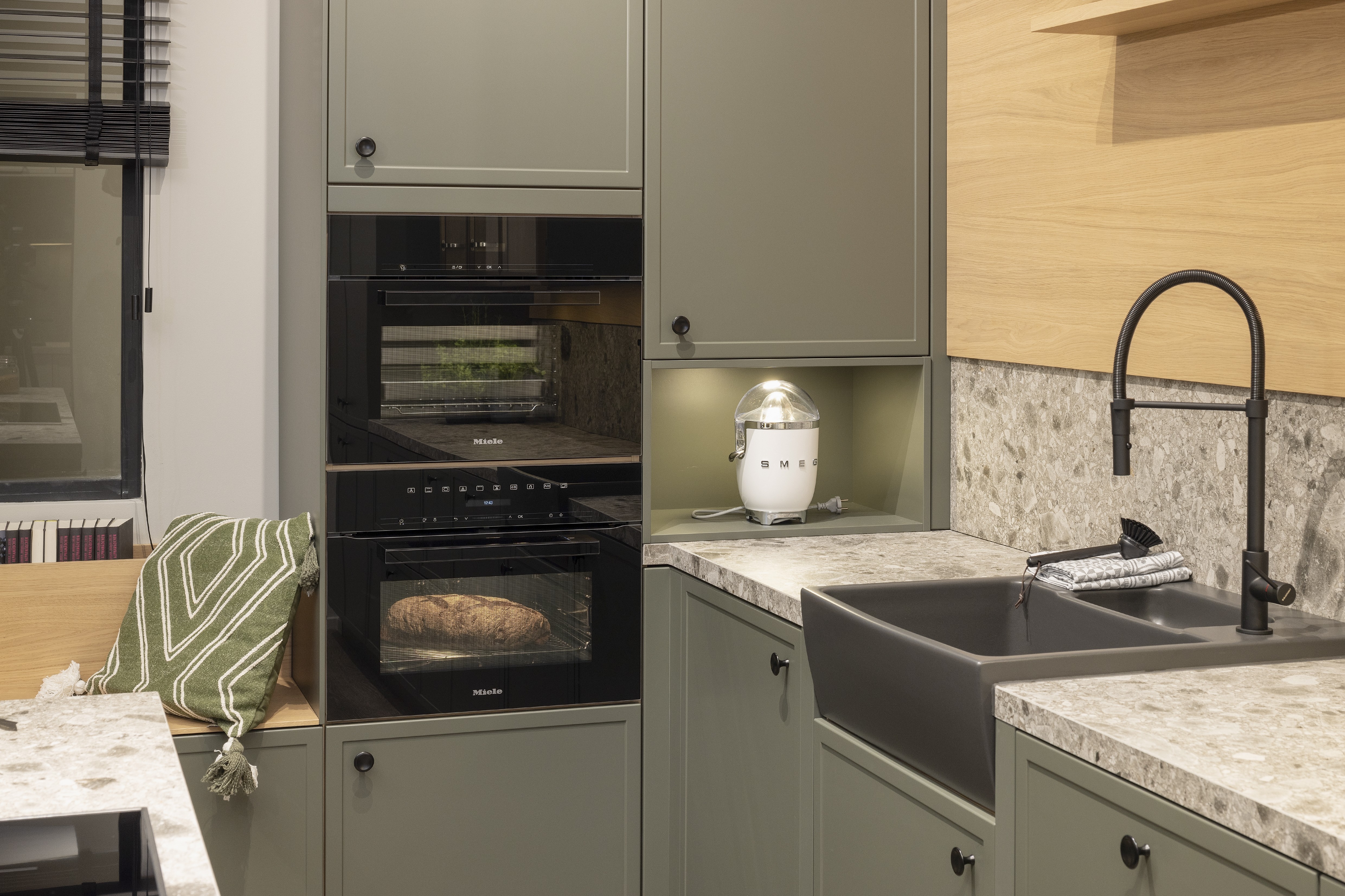 APL: Iseo Gris (Keramik) 40 mm Front: AV 5085 NCS S Mattlack (7005-G50Y)  Front 2: Feineiche-natur Repro Korpus: 2085 Designkorpus Feineiche-natur Griff: 113 Metall Schwarz-matt Geräte: Miele Armatur: Blaupunkt Spüle: Systemceram   Features:Keramik-Arbeitsplatte, Landhausküche modern, Nischenrückwand in APL-Material hochgezogen, Wandverkleidung in Vitrinen Material, Backofenkombi mit Kompaktbackofen, Sitzbank in Nischenmaterial, Spülbecken als Waschtisch aufgesetzt (Landhaus).