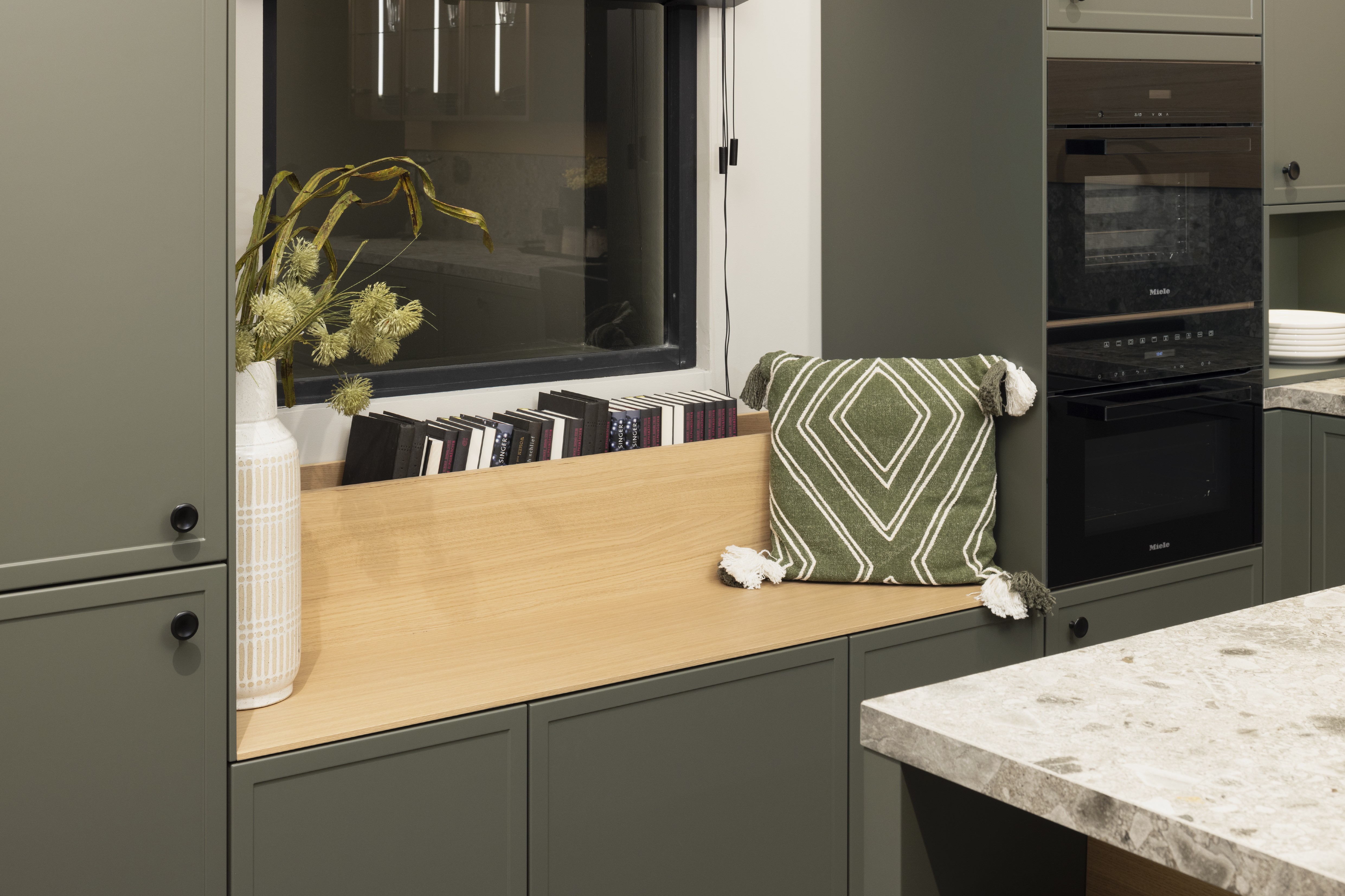 APL: Iseo Gris (Keramik) 40 mm Front: AV 5085 NCS S Mattlack (7005-G50Y)  Front 2: Feineiche-natur Repro Korpus: 2085 Designkorpus Feineiche-natur Griff: 113 Metall Schwarz-matt Geräte: Miele Armatur: Blaupunkt Spüle: Systemceram   Features:Keramik-Arbeitsplatte, Landhausküche modern, Nischenrückwand in APL-Material hochgezogen, Wandverkleidung in Vitrinen Material, Backofenkombi mit Kompaktbackofen, Sitzbank in Nischenmaterial, Spülbecken als Waschtisch aufgesetzt (Landhaus).