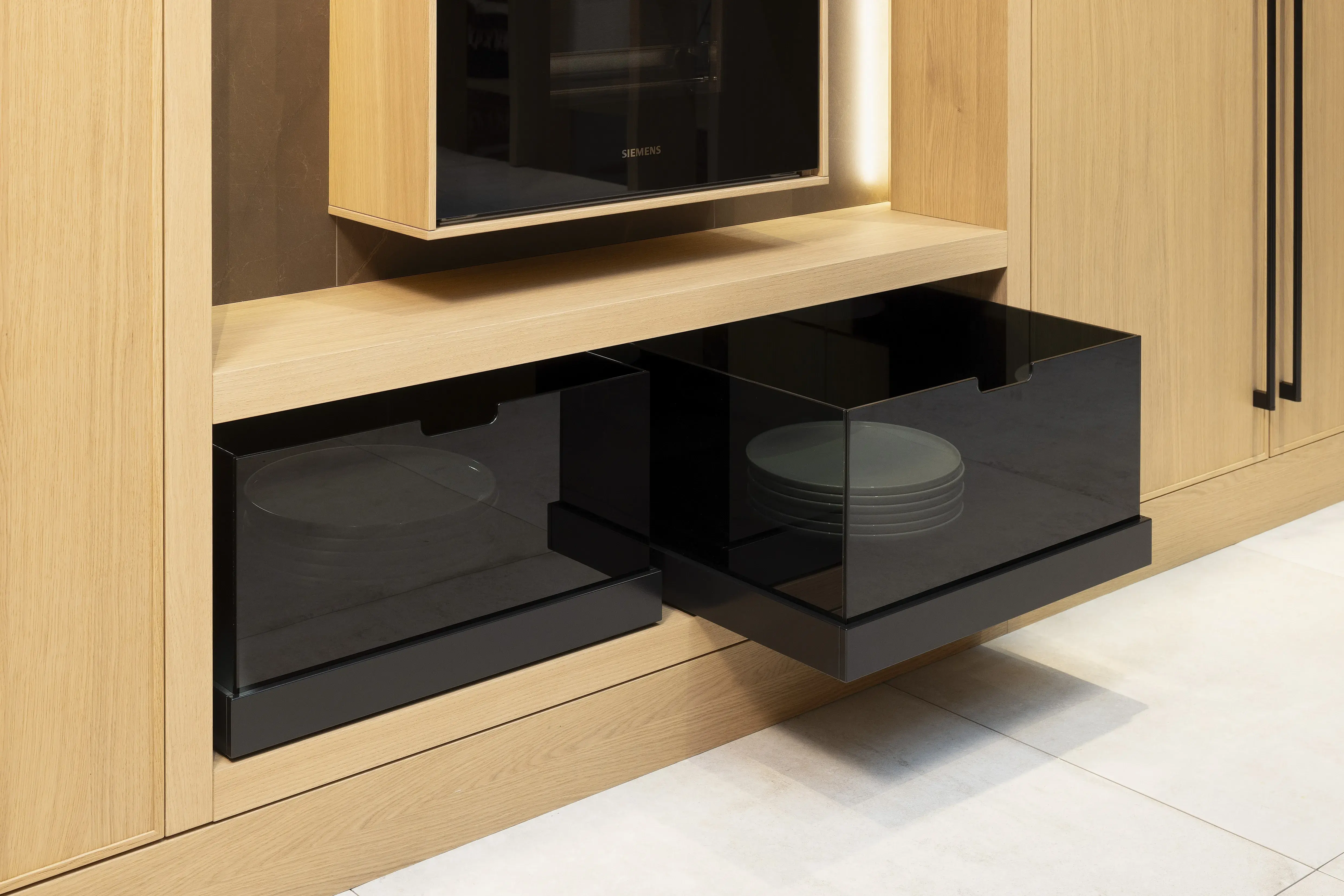 APL: Pulpis (Keramik) 25 mm Front: AV 6085-GL Eiche-elegant Echtholzfurnier (PURemission) Korpus: 2085 Designkorpus Feineiche-natur Griff: Kehlleiste 355 Schwarz matt Geräte: Siemens  Armatur: Gessi Spüle: ?  Features: neue Oberfläche Wiener Geflecht in Echtholzfurnier, Oberflächenmix, Waschbecken (Spülstein) in APL-Material, schwebende Arbeitsplatte durch Lichtleiste, APL abgekantet (schwebend), Backöfen in Wand eingekoffert, 3 Materialfarben.